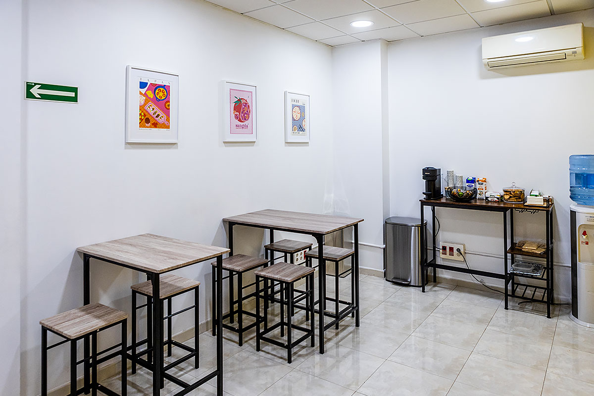 Lounge and coffee point at Sunlight School in Barcelona - tables, snacks, and a coffee machine