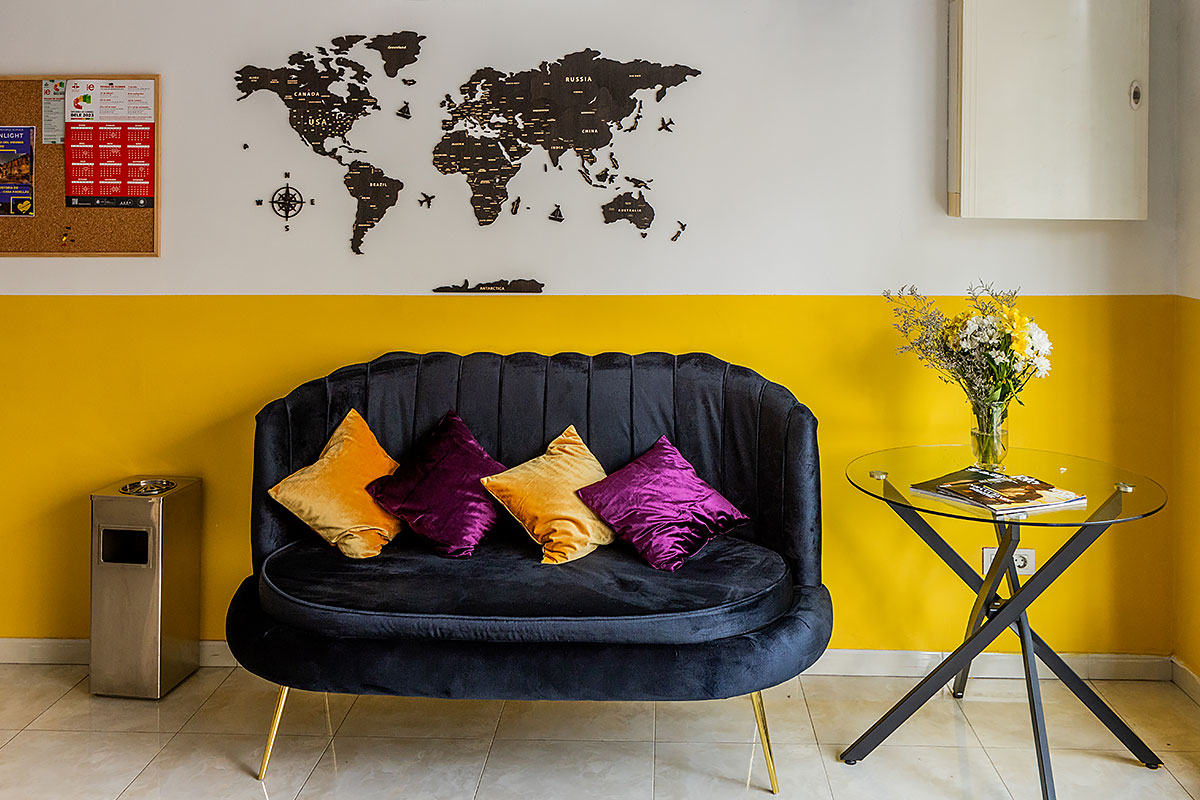 Cozy sofa with cushions and a world map at Sunlight School in Barcelona